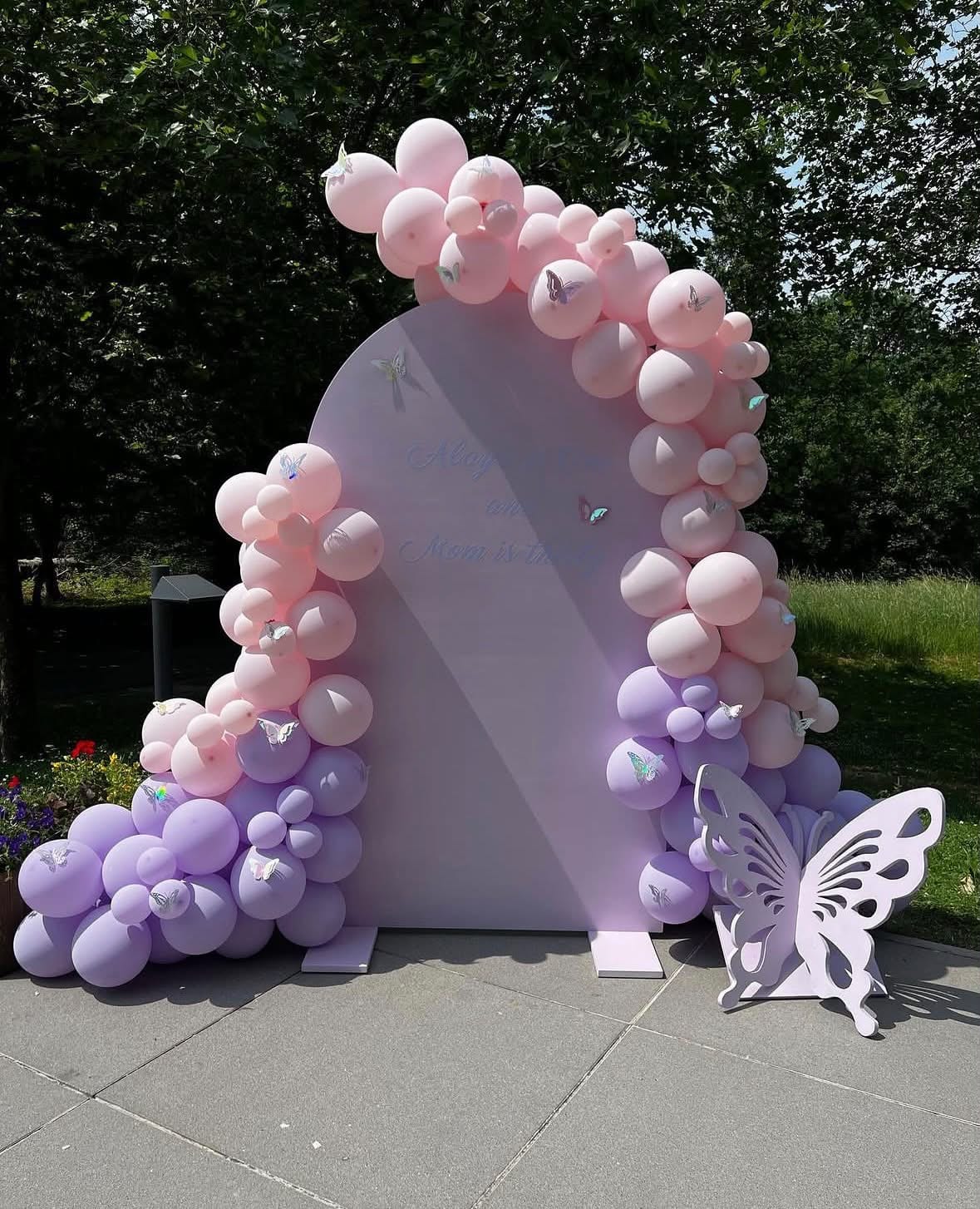 Arche rose et lilas ornée de papillons et ballons pastel